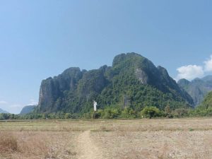 The cave rock in the middle of a field in Vang Vieng, Laos